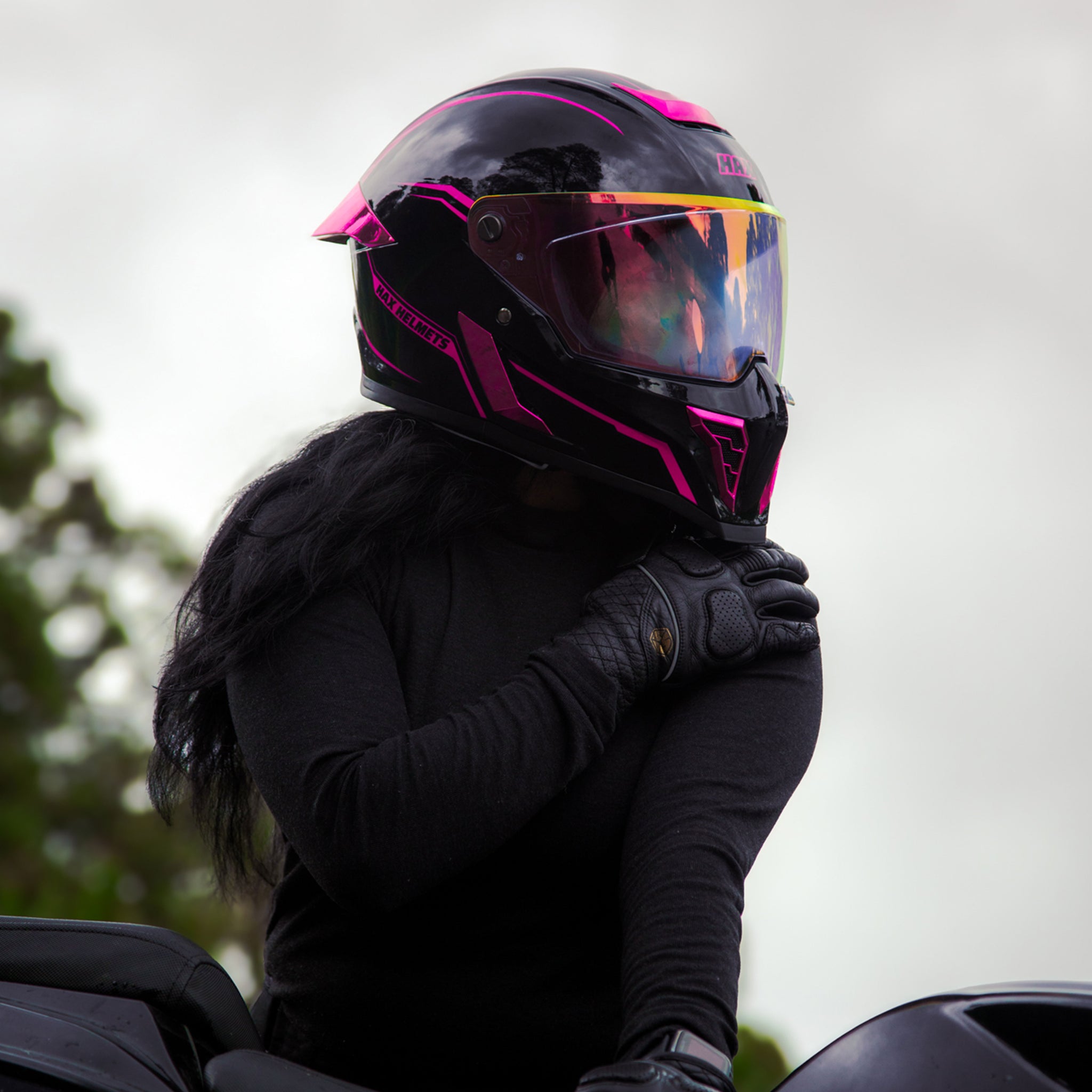 woman-motorcycle-rider-wearing-hax-black-pearl-pink-full-face-helmet-in-outdoor-setting